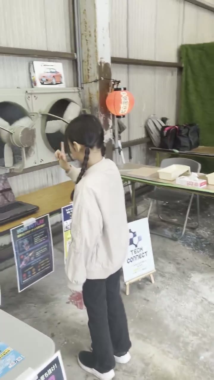 イベント会場で、的を狙う指のポーズでFinger Shot!を遊ぶ来場者